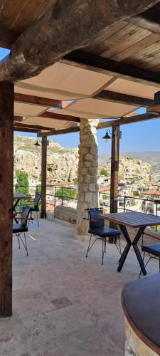 een patio met een tafel en stoelen en uitzicht bij Sirius Cave Cappadocia in Urgup