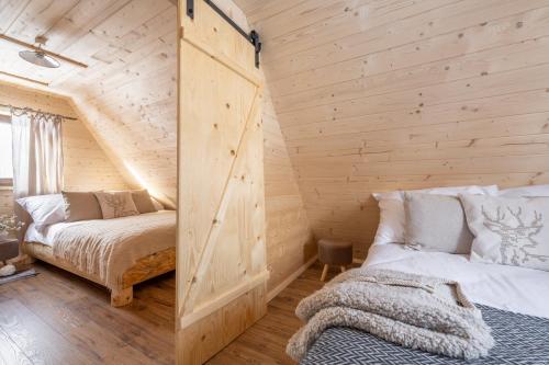 a bedroom with two beds in a log cabin at Leśna Chatka in Dzianisz