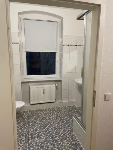 a bathroom with a window and a sink and a toilet at Komfortable Wohnung in Magdeburg