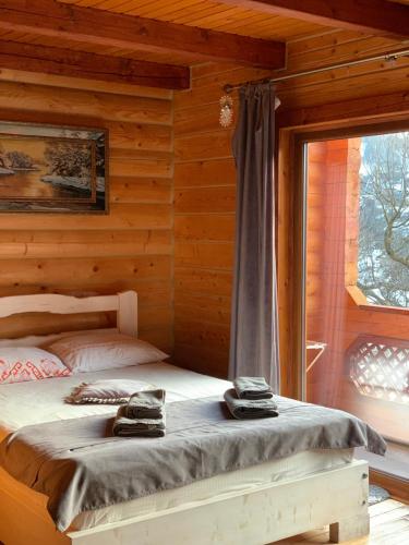 a bedroom with a bed in a log cabin at Готель Bliznuky in Vorokhta