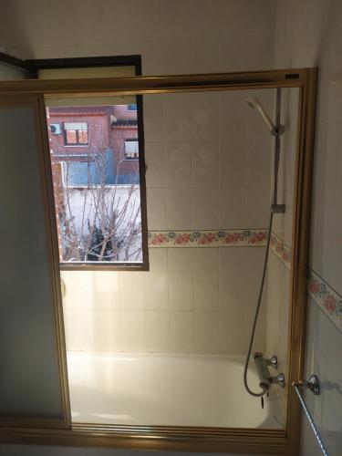 y baño con ducha y ventana. en Habitacion Privada Doble en Toledo en Toledo