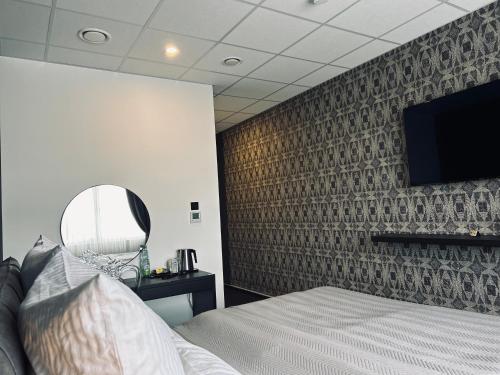 a bedroom with a bed and a wall with a tv at Firstclass Event & Hotel in Fürth