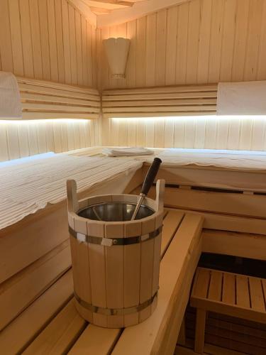 a tub in a sauna with a bed at GaujaClub - our BOSE and Bang&Olufsen lofts on a lake in Gauja