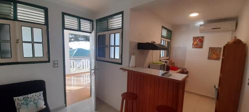 a room with a kitchen with a counter and windows at Résidence KAYA, Marie-Galante, Vue Mer in Grand-Bourg