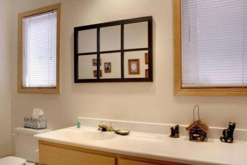 a bathroom with a sink and a mirror and a toilet at Lakefront Estate W/Stunning Views in Big Bear Lake in Big Bear Lake