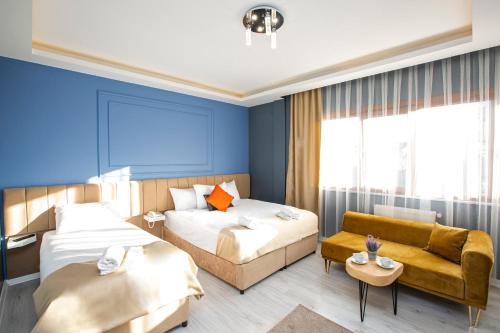 a hotel room with two beds and a couch at Taksim Leon's Hotel in Istanbul