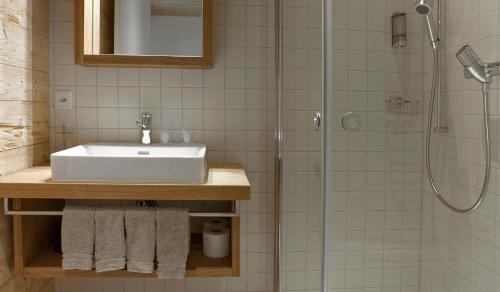 a bathroom with a sink and a shower at Bärghuis Jochpass - Alpine Hideaway - 2222müM in Engelberg