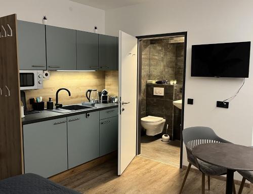 a kitchen with a sink and a toilet and a table at Rudolfquartier Linz, Rudolfstraße in Linz