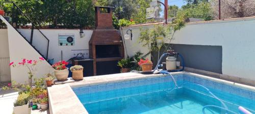 a swimming pool in a backyard with a garden at Casa con pileta cerca del Parque in Godoy Cruz