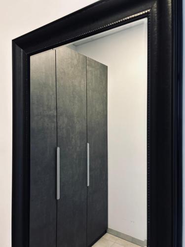 a black door with a mirror in a room at Firstclass Event & Hotel in Fürth