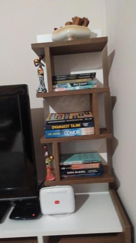 a book shelf with books on it next to a computer at Apartman S Pale in Pale