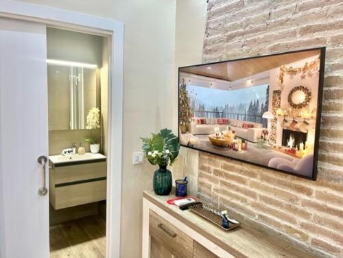 La salle de bains est pourvue d'un lavabo et d'un miroir sur un mur en briques. dans l'établissement Front Arc, à Barcelone