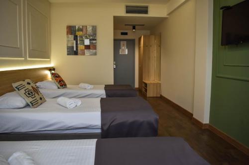 a room with two beds and a flat screen tv at Hotel Dijana in Pirot