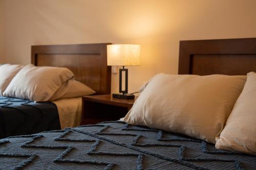 a hotel room with two beds and a lamp on a table at Estancia 105 in La Paz