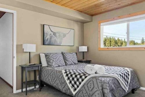 a bedroom with a bed with two lamps and a window at Base Camp New Ski Slope Views with HOT TUB. in Big Bear Lake