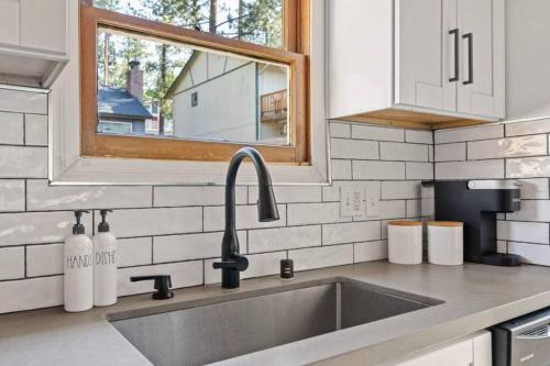 a kitchen counter with a sink and a window at Base Camp New Ski Slope Views with HOT TUB. in Big Bear Lake