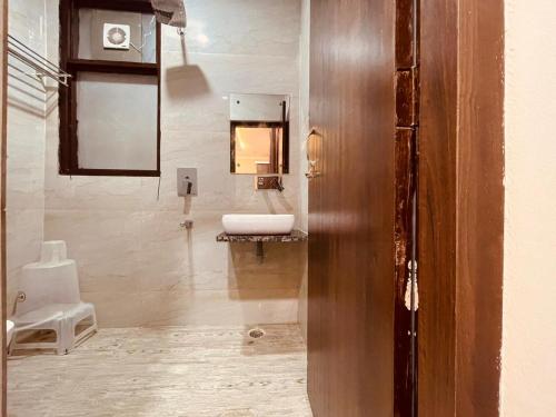 ein Bad mit einem Waschbecken und einem Spiegel in der Unterkunft Wooib Hotels, Haridwar in Haridwar