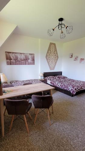 a room with a bed and a table and chairs at Willa Rąbanisko z sauną fińską in Dzianisz