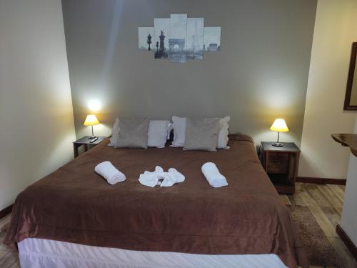 1 dormitorio con 1 cama grande y toallas. en Aconchego Do Lar, en Campos do Jordão