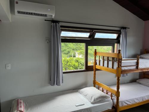 1 dormitorio con 2 literas y ventana en Santinho Hostel, en Florianópolis