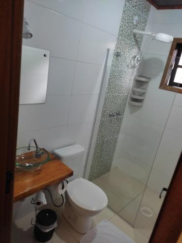 y baño con ducha, aseo y lavamanos. en Aconchego Do Lar, en Campos do Jordão