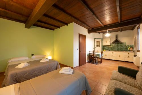 Casina的住宿－Agriturismo di Sordiglio，一间带两张床的卧室和一间带桌子的厨房