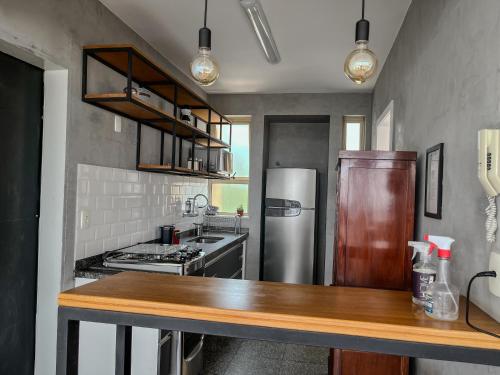 uma cozinha com um frigorífico de aço inoxidável e um balcão em Apartamento Centro/Sul BH em Belo Horizonte