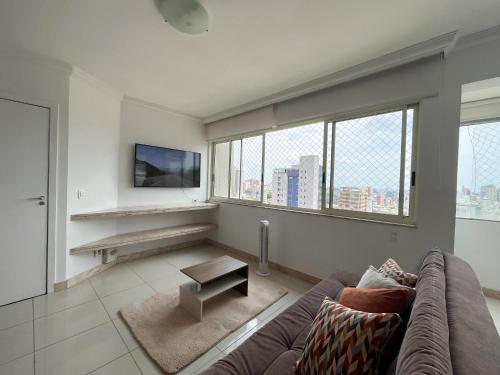 a living room with a couch and a tv at Apartamento Centro/Sul BH in Belo Horizonte