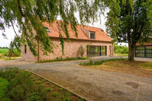 una casa de ladrillo con un árbol y una entrada en B&B Logie Jolie, en Ypres