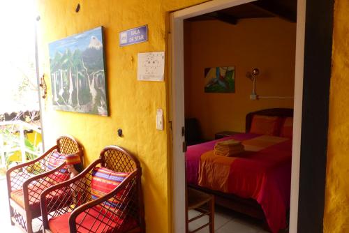 a bedroom with a bed and two wicker chairs at La Casa Amarilla in Baños