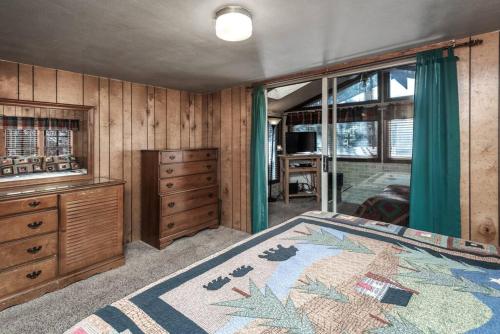 a bedroom with a bed and a dresser and windows at Coyote Cabin - Private Hot Tub - Upper Canyon in Ruidoso