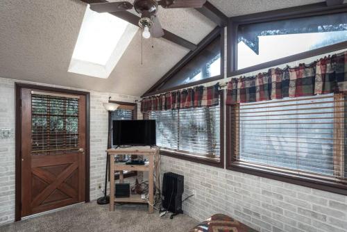 a living room with a ceiling fan and a tv at Coyote Cabin - Private Hot Tub - Upper Canyon in Ruidoso