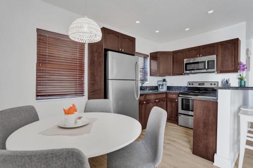 a kitchen with a white table and a white refrigerator at Waves On Walnut - Beach Access in Hollywood