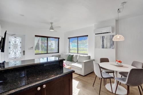 a kitchen and living room with a table and chairs at Waves On Walnut - Beach Access in Hollywood