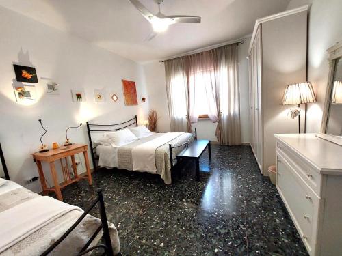 a bedroom with a bed and a desk and a bed and a window at Chianti Best House in Greve in Chianti