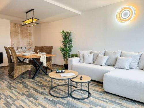 un salon avec un canapé blanc et une table dans l'établissement Le Roof Top - Parc des Expos - Roissy CDG, à Villepinte