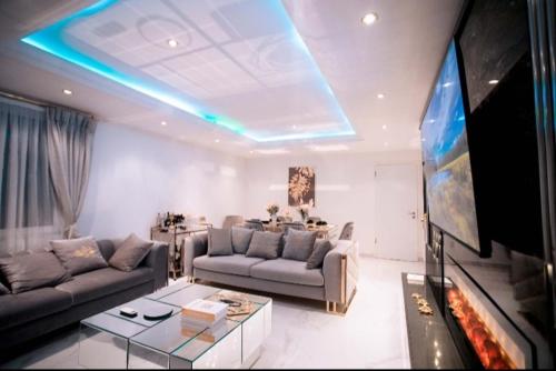 uma sala de estar com dois sofás e uma televisão em JQ Apartments Prime em Acra