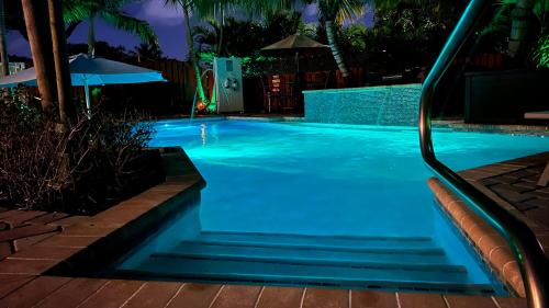 a swimming pool at night with blue water at Billy's Resort-Clothing Optional- Men Only - Solo Hombres in Wilton Manors