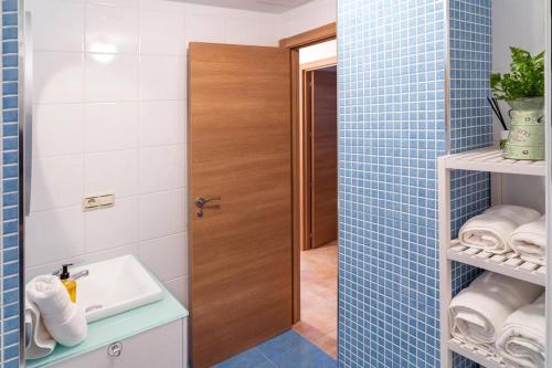 a bathroom with a sink and a shower with blue tiles at Apartamento Catuxa in Malpica