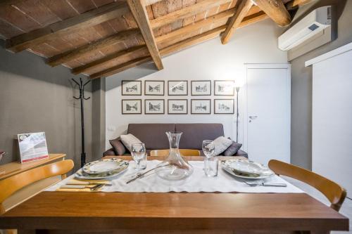 una mesa de madera con platos y vasos. en La Casa di Valeria - Modena, en Módena
