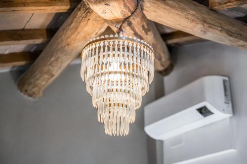 una lámpara de araña colgada de un techo de madera en La Casa di Valeria - Modena, en Módena