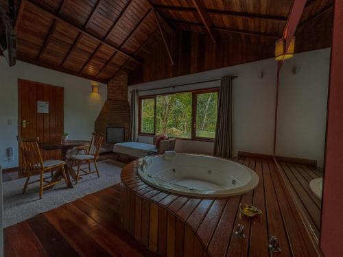 ein großes Bad mit einer großen Badewanne in einem Zimmer in der Unterkunft Pousada Recanto do Escorrega in Visconde De Maua