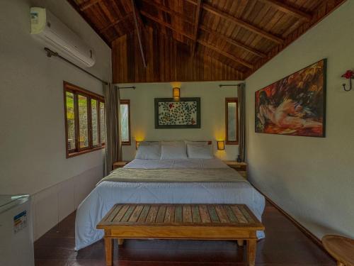 - une chambre avec un lit et une table dans l'établissement Pousada Recanto do Escorrega, à Visconde de Mauá