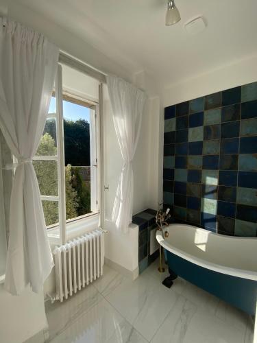 La salle de bains est pourvue d'une baignoire et d'une fenêtre. dans l'établissement Brittany Carantec Morlaix, à Saint-Martin-des-Champs