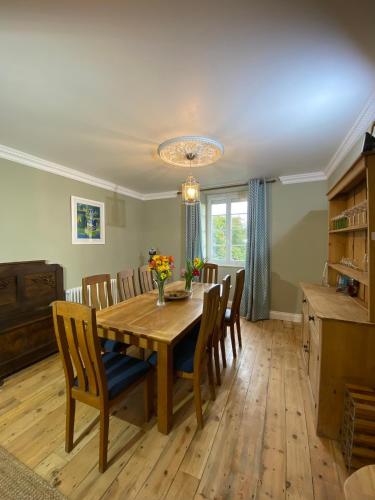 une salle à manger avec une table et des chaises en bois dans l'établissement Brittany Carantec Morlaix, à Saint-Martin-des-Champs