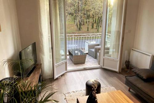 d'un salon avec une grande porte coulissante en verre. dans l'établissement Logement à Brive près de la campagne et centre-ville, avec parking privé, climatisation, et double balcon privé, à Brive-la-Gaillarde