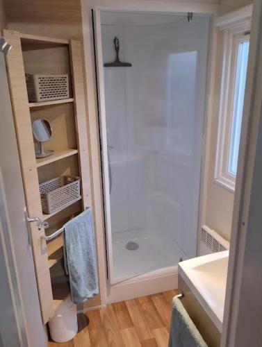 une salle de bain blanche avec une douche et un lavabo dans l'établissement Belle location sur Lumio avec vue remarquable et jardin, à Lumio