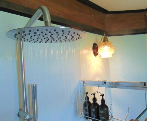 a shower head with icicles and bottles of wine at Raglan's Tranquil Garden Retreat - Moa Stone Lodge in Raglan