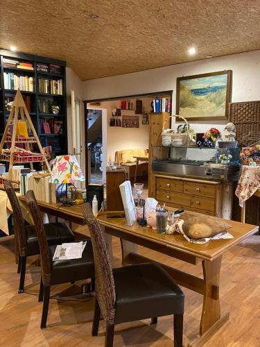 a room with a table and chairs and a kitchen at Schumacher's Landhaus - Bücherhotel in Friedeburg