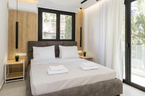 a bedroom with a large bed with two towels on it at Varkiza Luxury Suites in Vari